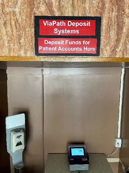 
			La imagen muestra el terminal de depósito de tarjetas de crédito del hospital, situado en el vestíbulo principal, con un cartel rojo que dice 'ViaPath Deposit Systems; Deposit Funds for Patient Accounts' colocado encima.